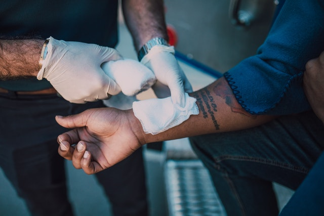 A medical professional applying a bandage to stop the bleeding