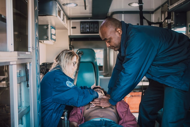 Two medical experts performing CPR in an ambulance