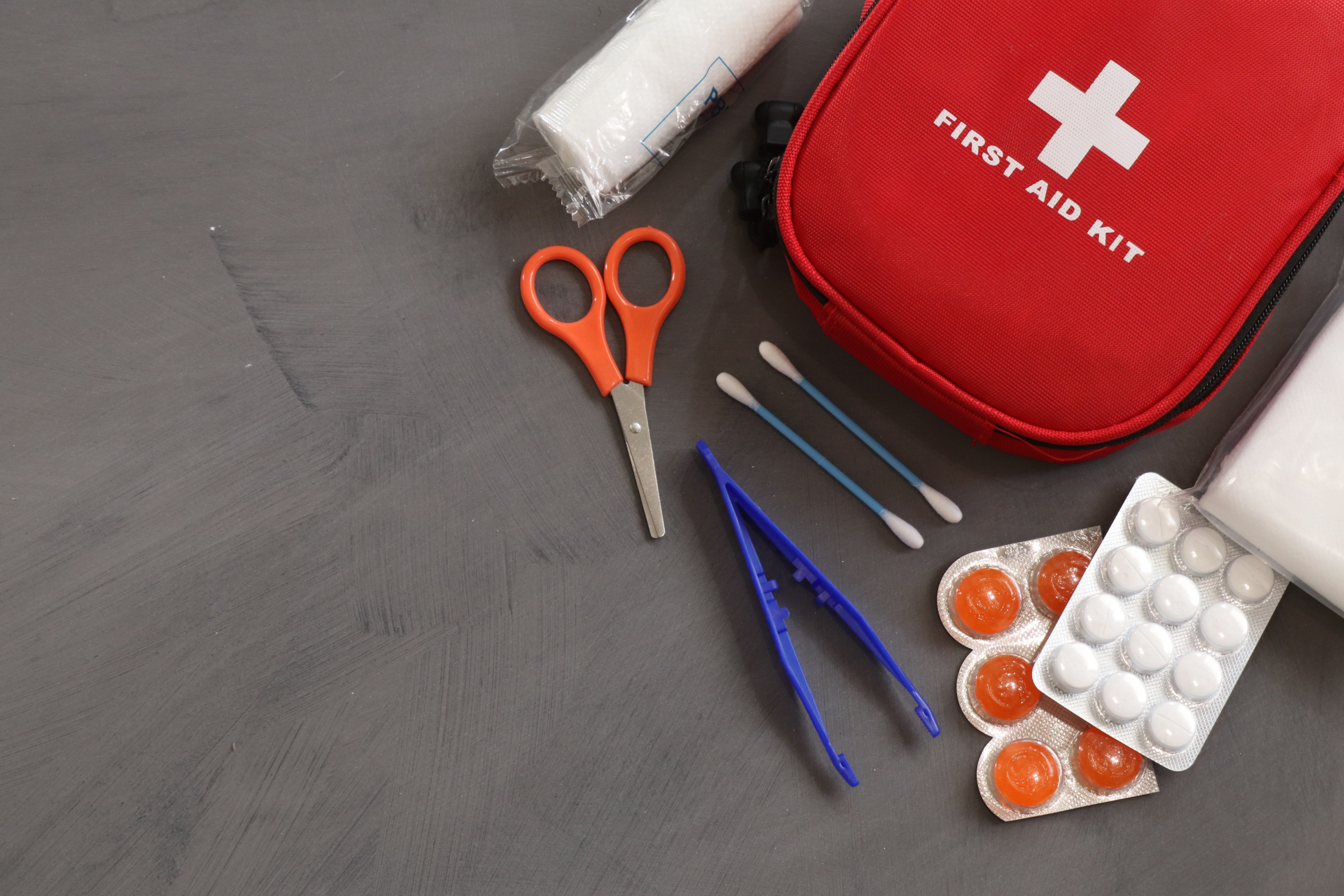 First aid kit with medical supplies arranged for workplace emergency preparedness.