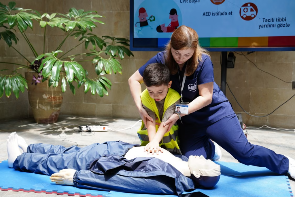Instructor leading CPR and first aid training by demonstrating proper chest compressions.