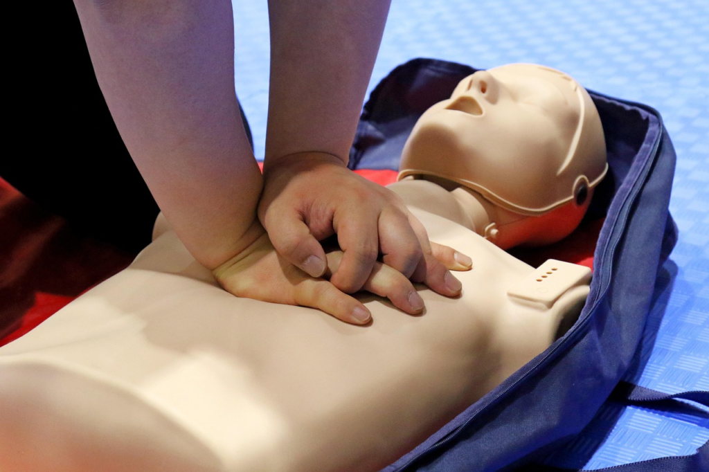 A person performing CPR on a mannequin
