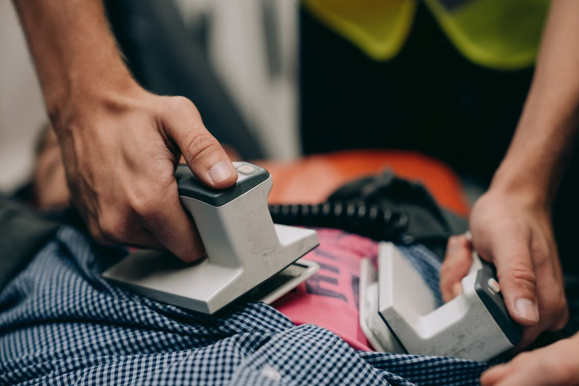 A person using a defibrillator on a patient
